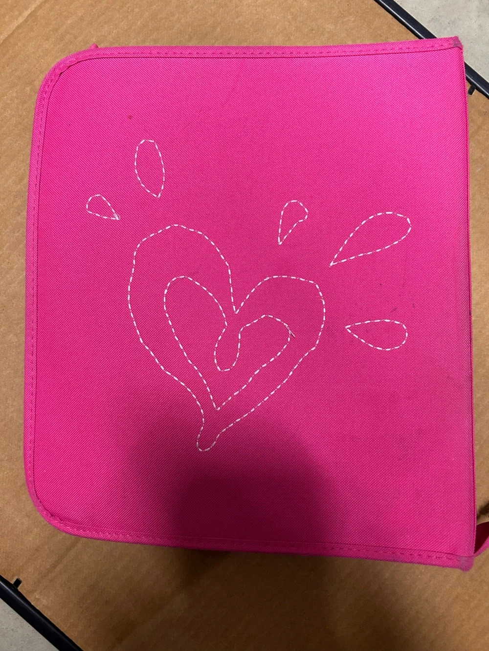 Hot pink, 3 ring binder notebook that zips up and has sequins on the front.